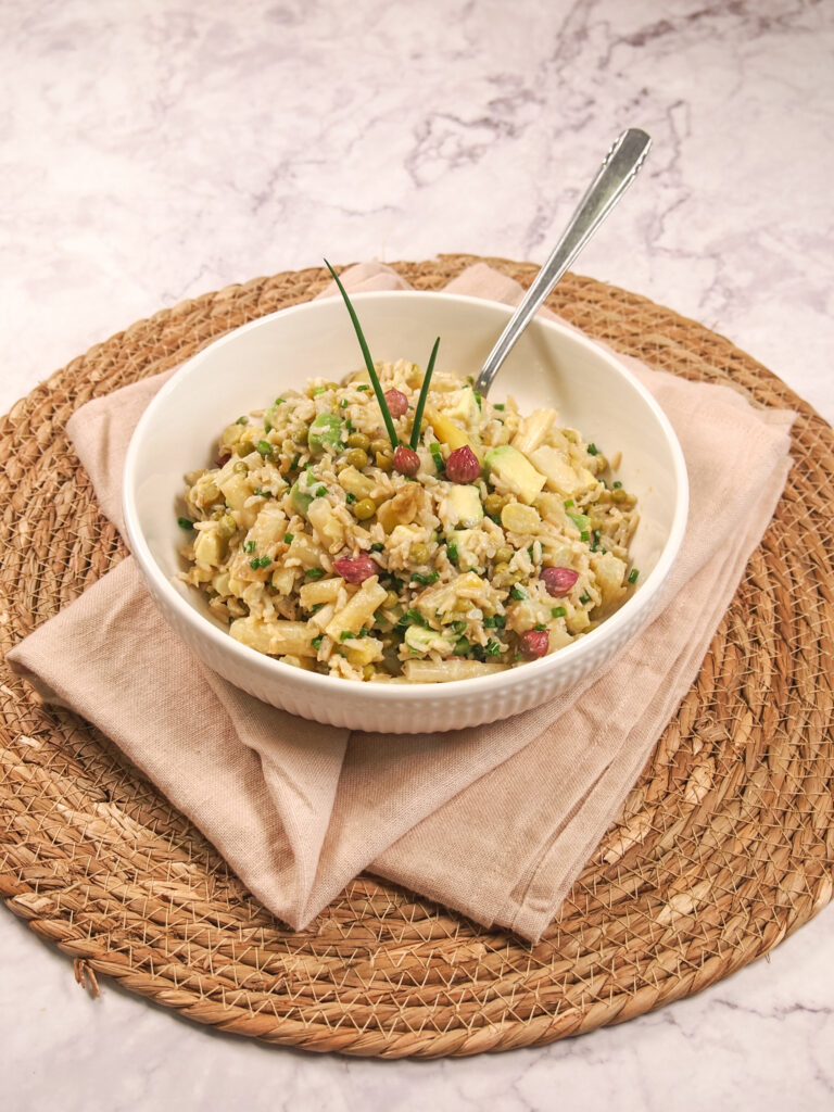 Spargel-Reis-Salat mit Schnittlauch in Schüssel auf Serviette